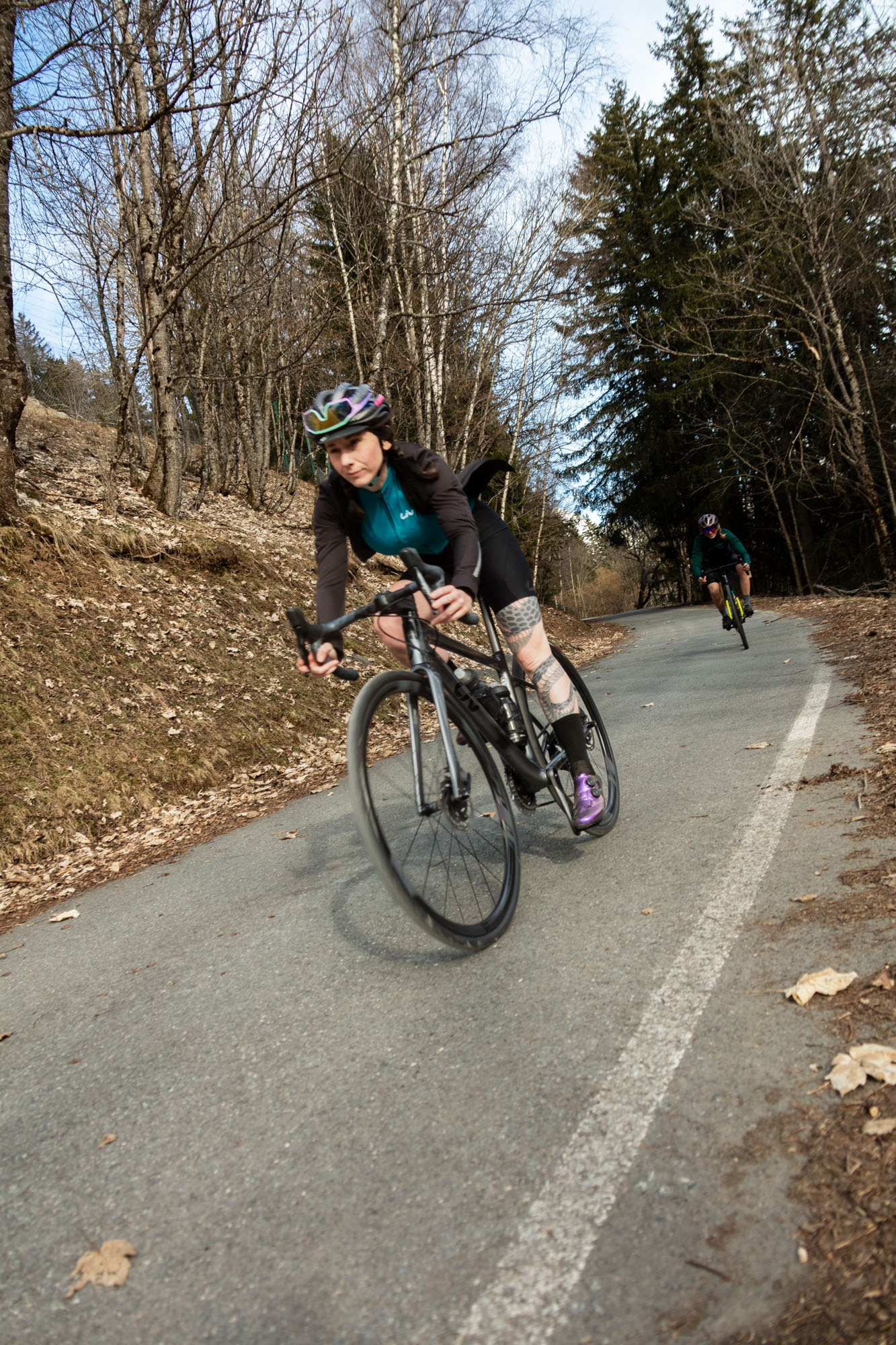 Cycliste GLOW en virage sur route de montagne