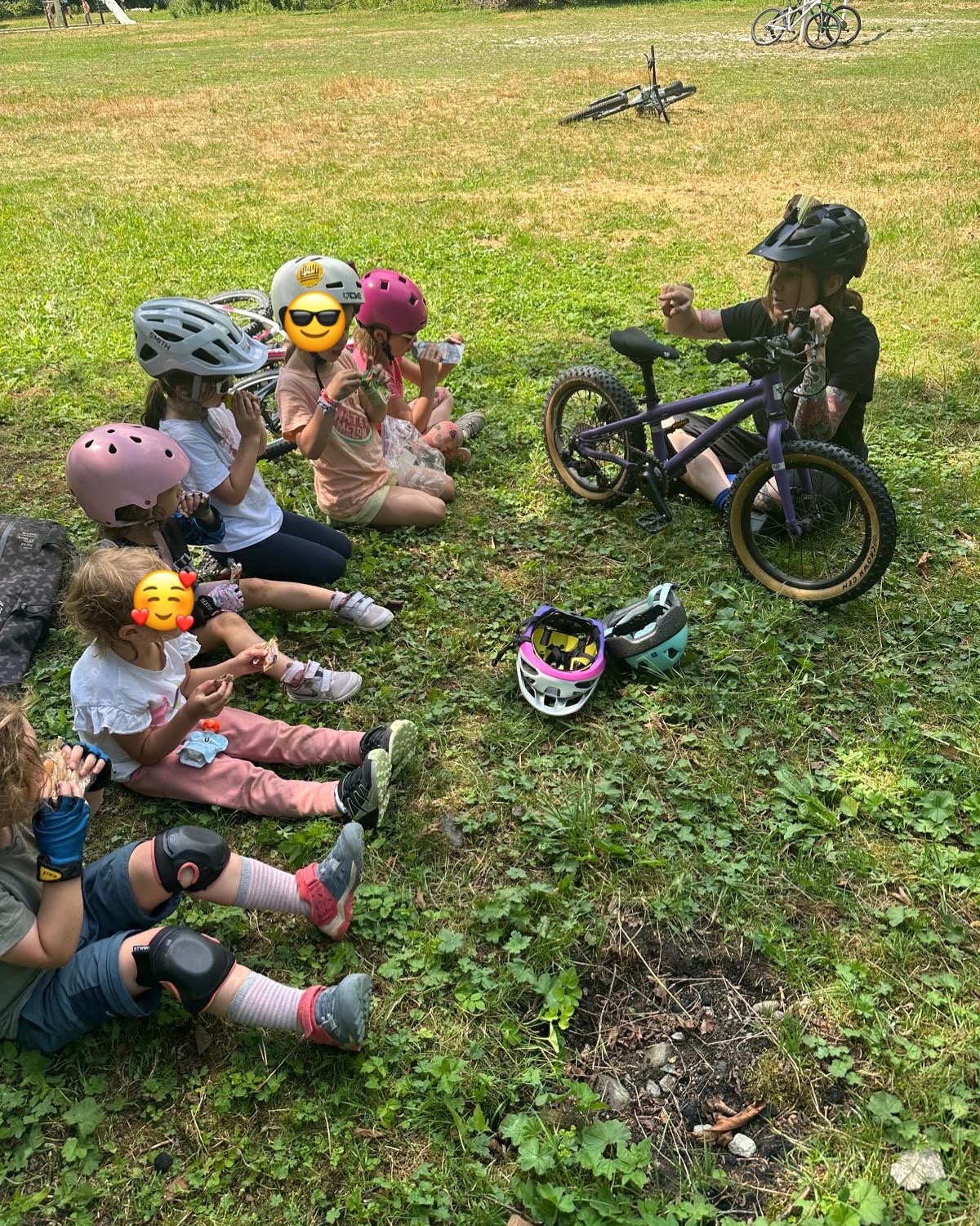 Coach GLOW expliquant le parcours à un groupe de jeunes vététistes dans l'herbe